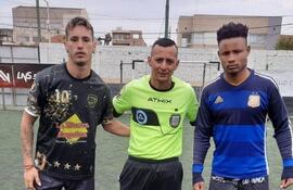 Un encuentro amigable en la previa: La Cortada vs El Rejunte. Los dos capitanes. El agresor Alexander Williams Tapón extiende su brazo hacia la espalda del árbitro.