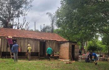 Un grupo de colonos de Potrerito, distrito de Capiibary, trabajan en la reparación del puesto de salud de la comunidad,