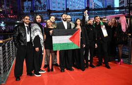 El director palestino Abdallah Alkhatib (2º izq., también escrito Abdallah Al-Khatib) y el equipo de la película Chronicles From the Siege sostienen una bandera palestina mientras llegan a la alfombra roja de la ceremonia de premiación de la 76ª Berlinale, el primer gran festival de cine del año en Europa, en Berlín, el 21 de febrero de 2026.