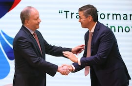 Fotografía de archivo del 21 de octubre de 2025 del ministro renunciante de economía Carlos Fernández Valdovinos (i), saludando al presidente de Paraguay, Santiago Peña, durante un evento.