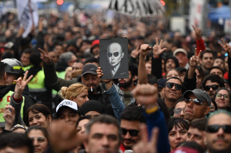 Un seguidor del cantante argentino Carlos Alberto 'Indio' Solari, sostiene una imagen durante una ceremonia pública para despedir al cantante este domingo.