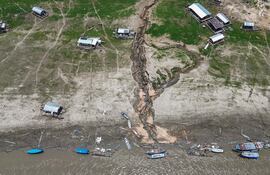 Fotografía aérea que muestra casas flotantes y embarcaciones encalladas en el río Manacapuru, uno de los afluentes del río Solimões, en Manacapuru, Amazonas (Brasil). Las sequías y crecidas extremas que se producen actualmente en varias partes del mundo son un “indicador” de las evoluciones futuras, con un ciclo del agua más irregular debido al cambio climático, advirtió la ONU el lunes.