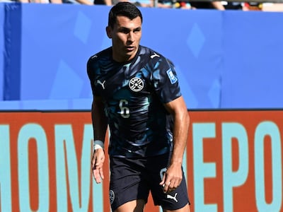 Junior Alonso, con camiseta azul oscuro y número 6, se prepara para patear el balón en un estadio lleno de espectadores.