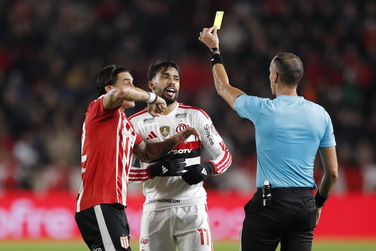 El arbitro Juan Gabriel Benítez (d) muestra trajeta amarilla a Lucas Paquetá (c) de Flamengo este jueves, en un partido de semifinales de la Copa Libertadores entre Estudiantes L.P. y Flamengo en el estadio Jorge Luis Hirschi en La Plata (Argentina).