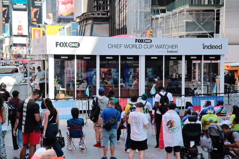 Las personas observan mientras Austin Franklin y Kevin Akoto, los principales "Observadores del Mundial" de FOX, ven el partido de la Copa del Mundo entre Senegal y Francia en Times Square.