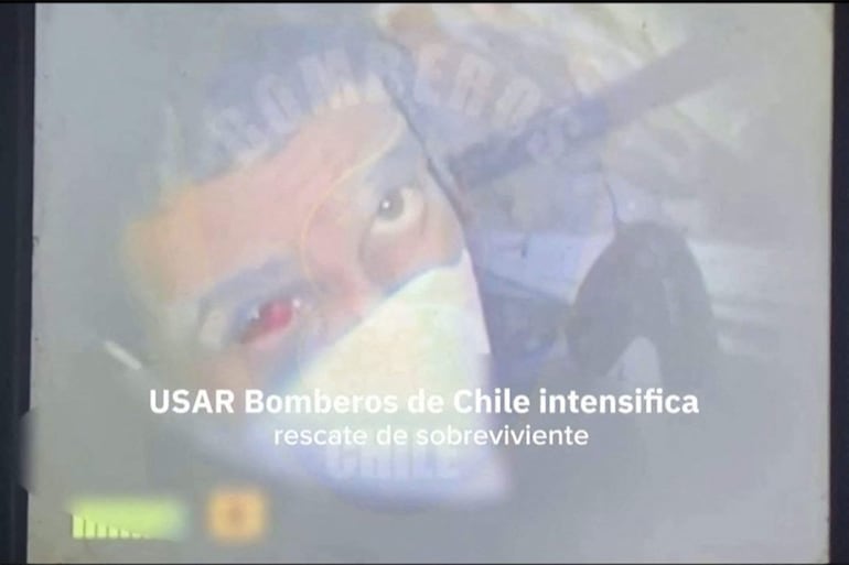 Esta captura de pantalla hecha a partir de un video distribuido el 2 de julio de 2026 por Bomberos de Chile muestra al guardia de seguridad Hernán Gil, de 43 años, atrapado entre los escombros en Catia La Mar tras los dos terremotos que golpearon Venezuela el 24 de junio de 2026. Cientos de rescatistas lucharon el 2 de julio de 2026 por sacar a un hombre venezolano de 43 años que llevaba ocho días atrapado bajo un edificio colapsado.
