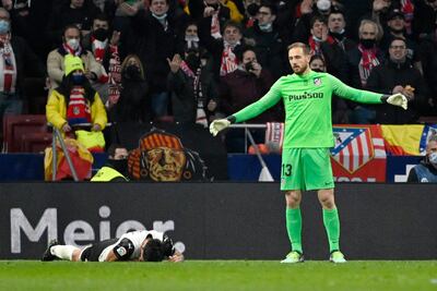 Omar Alderete, defensor del Valencia, tendido en el césped ante la mirada de Jan Oblak, el arquero del Atlético Madrid.
