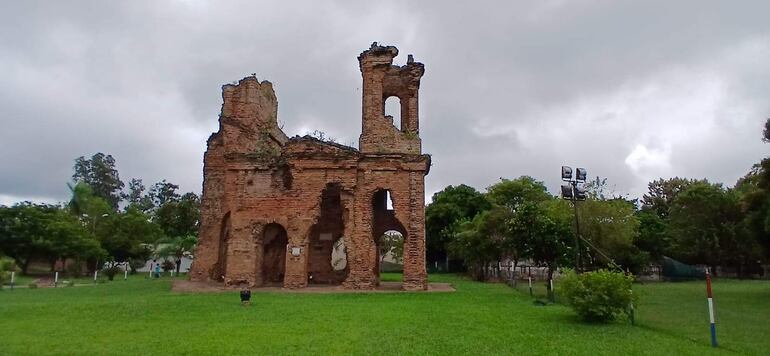 Estructura en ruinas de un antiguo edificio en Humaitá, rodeada de césped y árboles, bajo un cielo nublado.