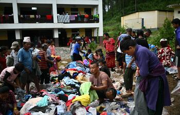 Supervivientes de una inundación repentina recogen ayuda en un centro de asistencia temporal en Devghat, en el distrito nepalí de Nuwakot, el 5 de septiembre de 2026.