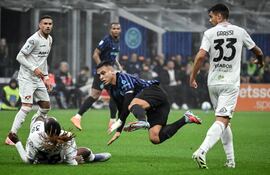 Lautaro Martínez, figura goleadora argentina del Inter de Milán, comete una falta en una acción observada con detenimiento por el paraguayo Arnaldo Antonio Sanabria.