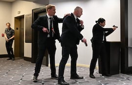 Agentes desenfundan sus armas tras escucharse fuertes disparos durante la cena de corresponsales de la Casa Blanca en el hotel Washington Hilton de Washington, D.C., el 25 de abril de 2026. El presidente Trump asiste por primera vez a la gala anual de la prensa política durante su mandato