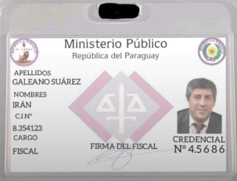 Credencial del Ministerio Público con nombre de Irán Galeano Suárez y foto de un hombre con traje oscuro, en fondo blanco.