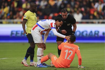 Roberto Jr. Fernández (sentado), arquero de la selección de Paraguay, recibe atención luego de una falta en el partido contra Ecuador por las Eliminatorias Sudamericanas 2026 en el estadio Rodrigo Paz Delgado, en Quito, Ecuador.