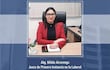 Nélida Alvarenga con abrigo rojo, sentada en su escritorio con brazos cruzados y mirada directa, en ambiente de oficina.