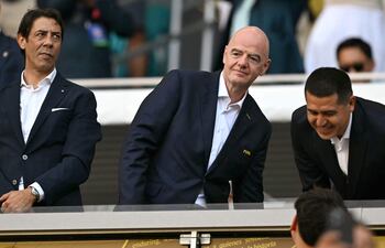 El presidente de la FIFA, Gianni Infantino (C), el presidente del Benfica, Rui Costa (I), y el presidente de Boca Juniors, Juan Román Riquelme, asisten al partido de fútbol del Grupo C de la Copa Mundial de Clubes de la FIFA 2025 entre Boca Juniors de Argentina y Benfica de Portugal en el estadio Hard Rock de Miami.