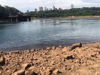 Los pilares del muelle ubicado en el límite entre Presidente Franco y Ciudad del Este sobresalen en el Río Paraná. Atrás los edificios de Foz de Iguazú.
