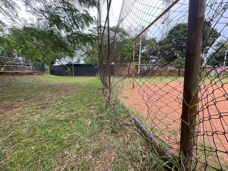 Campo de fútbol sin personas, con césped y portería, bajo un cielo nublado en un ambiente tranquilo.