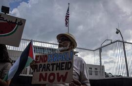 Pro-Palestinian activists hold banners and flags as they demonstrate following the International Court of Justice (ICJ) ruling of the case against Israel brought by South Africa in The Hague at the U.S. Consulate in Johannesburg on January 26, 2024. South African lawyers presented their case at the UN's top court in The Hague, where South Africa lodged an urgent appeal to force Israel to "immediately suspend" its military operations in Gaza. The International Court of Justice (ICJ) ruled on January 26, 2024 that it has jurisdiction over the genocide case. (Photo by DAVIDE LONGARI / AFP)