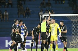 El árbitro David Ojeda exhibe la cartulina amarilla al portero de Olimpia, Gastón Olveira, tras el tanto de apertura de Fernando Matías Cáceres.