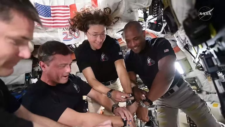 Esta captura de pantalla de una transmisión en vivo de la NASA muestra a los miembros de la tripulación de Artemis II, Jeremy Hansen, Reid Wiseman, Christina Koch y Victor Glover, sincronizando sus relojes a bordo de la nave espacial Orion el 6 de abril de 2026.