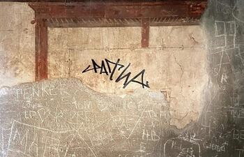 Un turista de Países Bajos ha garabateado su firma en rotulador indeleble en una pared con frescos de una casa de época romana en el parque arqueológico de la antigua ciudad de Herculano, en Italia, sepultada por el Vesubio junto a Pompeya el año 79 d.C.
