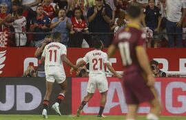 El delantero nigeriano del Sevilla Chidera Ejuke (c) celebra con sus compañeros tras anotar un tanto durante el partido de la jornada 7 de LaLiga EA Sports disputado este martes en el estadio Sánchez Pizjuán de Sevilla.
