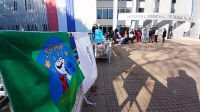 Grupo de personas con bandera del SIFIPSAP, algunos sentados y otros de pie, en un ambiente exterior bien iluminado.
