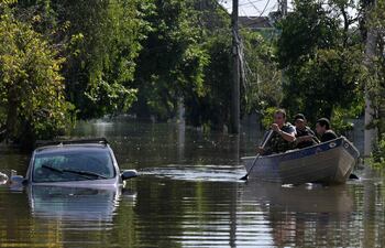 Locals move in boats following floodings due to heavy rains in Porto Alegre, Rio Grande do Sul state, Brazil on May 6, 2024. From top to bottom, rescuers scour buildings in Porto Alegre for inhabitants stuck in apartments or on rooftops as unprecedented flooding killed at least 78 people in the southern state, with dozens missing and some 115,000 forced to leave their homes. (Photo by NELSON ALMEIDA / AFP)