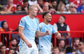 Erling Haaland, del Manchester City (i), lo celebra con sus compañeros tras marcar el gol de 0-1 durante el partido de la Premier League inglesa disputado entre el Manchester United y el Manchester City, en Mánchester, Gran Bretaña,
