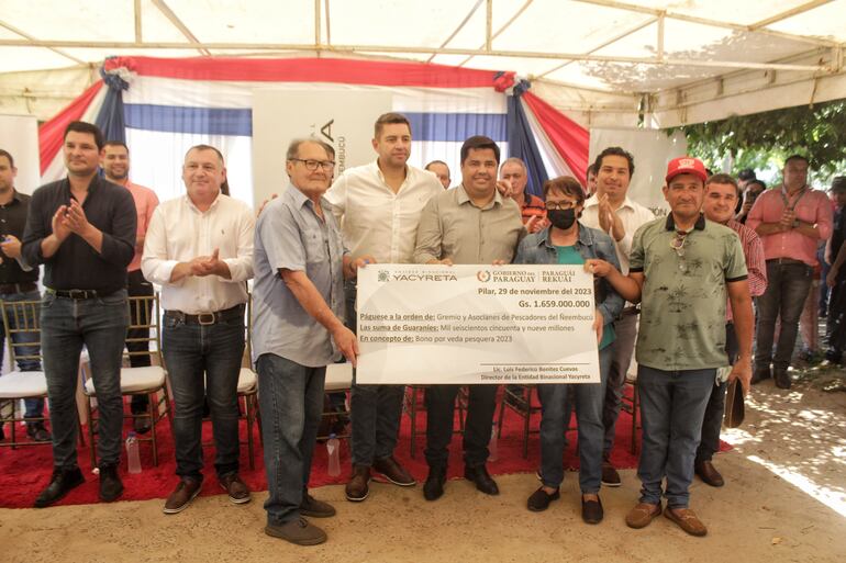 El Vicepresidente de la República,Pedro Alliana y el director de la EBY Luís Benítez, hacen entrega de un cheque simbólico a la Asociación de pescadores de Ñeembucú.