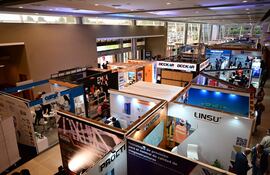 Diversos stands de empresas en la feria CONSTRUTECNIA 2026, iluminado y moderno, con carteles de OZOX, LINDEN y PROETI.