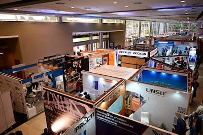 Diversos stands de empresas en la feria CONSTRUTECNIA 2026, iluminado y moderno, con carteles de OZOX, LINDEN y PROETI.