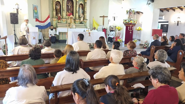 Monseñor Osmar López, vestido con ropas religiosas, habla desde el podio mientras la audiencia escucha atentamente en un ambiente decorado.