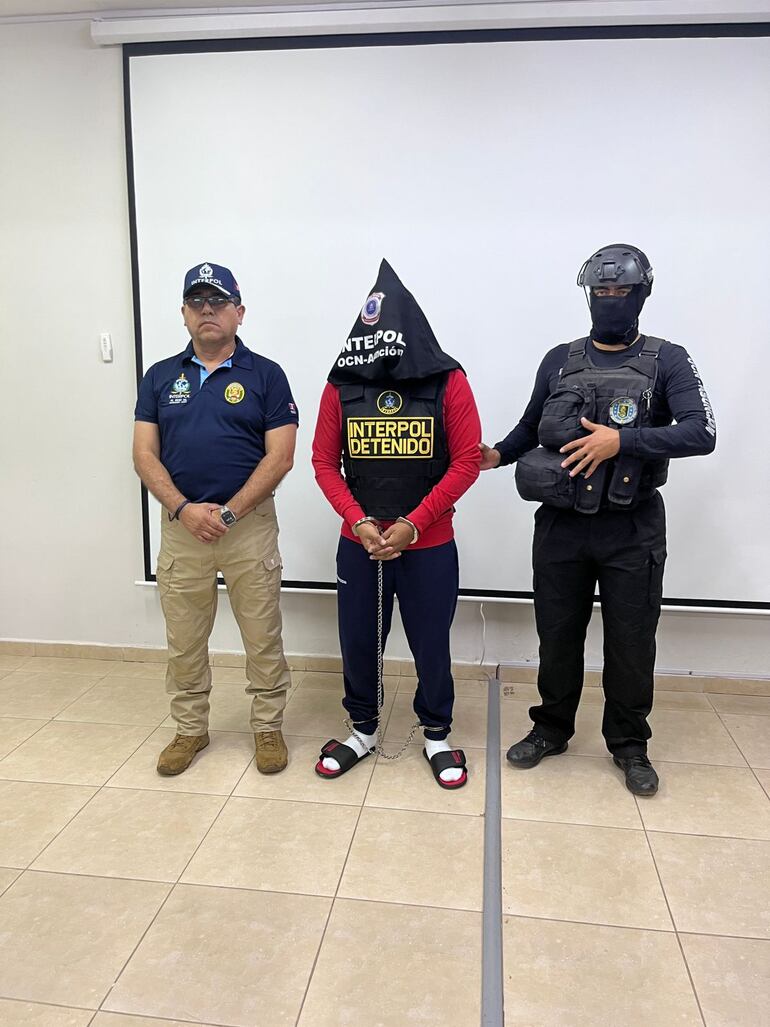 Con capucha, flanqueado por agentes policiales, Erick Luis Moreno Hernández (34).