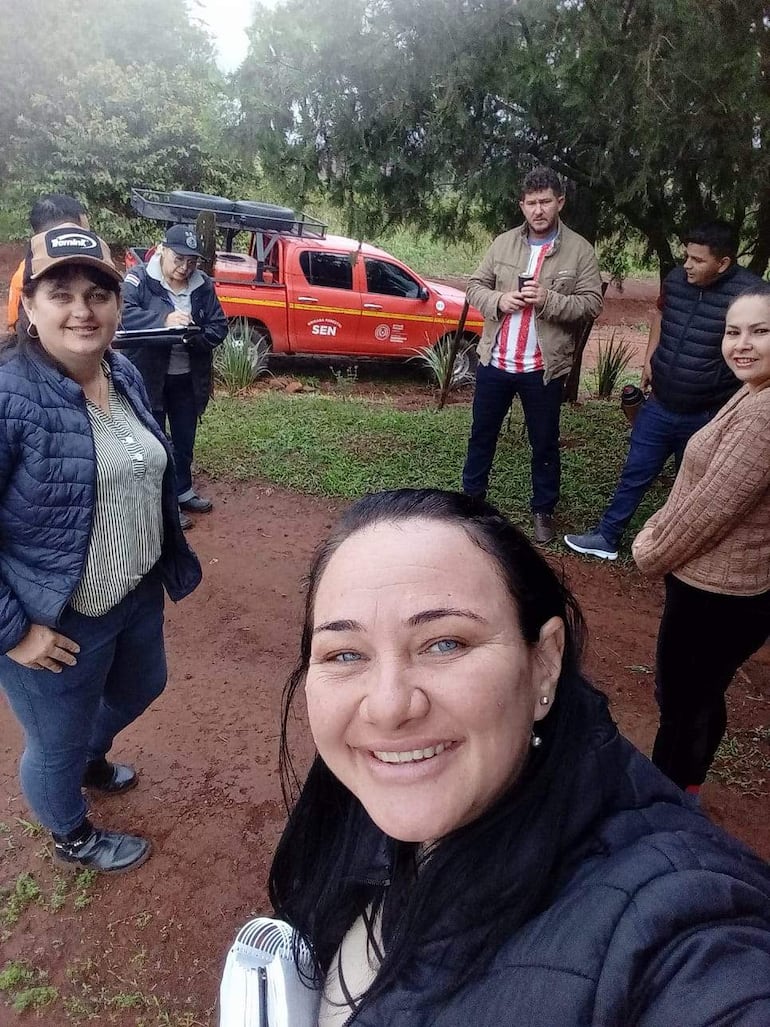 Mujeres y hombres sonrientes rodean a Ernan Volken, vestido con camiseta albirroja, en un ambiente rural y natural.