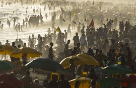 Personas observan el atardecer este miércoles, en la playa de Ipanema en Río de Janeiro (Brasil).
