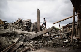 Un hombre sobre un montón de escombros en Quibdó, Colombia.