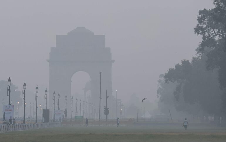 Personas caminan en medio de una densa niebla tóxica cerca de Rajpath en Nueva Delhi, India, el 31 de octubre de 2025.