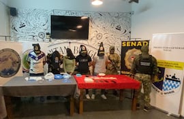 Los cinco detenidos por los organismos de control, posan con las evidencias incautadas durante el operativo.