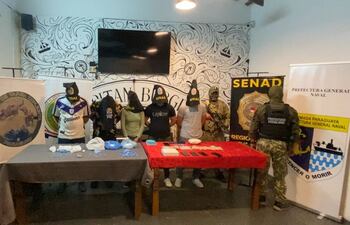 Los cinco detenidos por los organismos de control, posan con las evidencias incautadas durante el operativo.