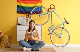 Mujer sentada en el piso lee un libro.