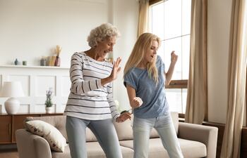 Mujer mayor baila con su hija.