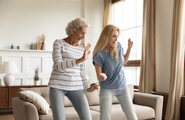 Mujer mayor baila con su hija.