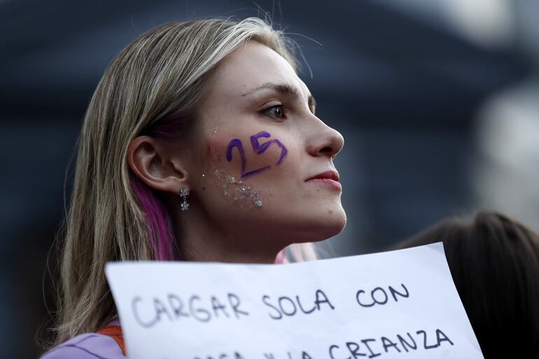Una mujer sostiene un cartel durante una marcha como parte del Día Internacional de Eliminación de la Violencia contra la Mujer este martes, en Asunción.