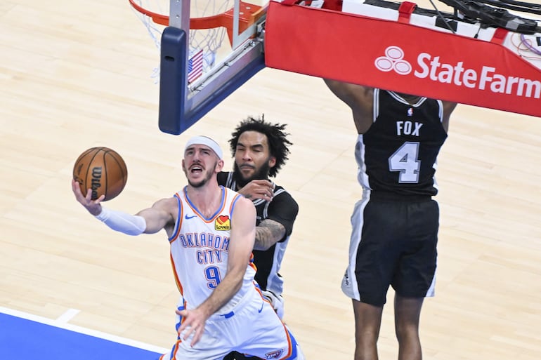 Alex Caruso de OKC intenta una bandeja de espalda ante Justin Champagnie. durante el juego 5 de las finales de la Conferencia Oeste.