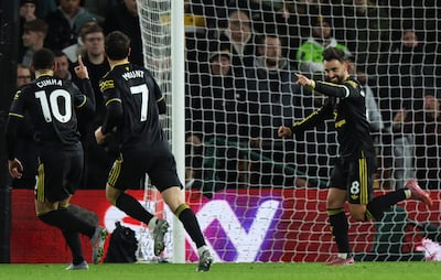 El mediocampista portugués del Manchester United Bruno Fernandes (D) celebra la anotación del gol inaugural con el delantero brasileño del Manchester United Matheus Cunha (I) durante el partido de fútbol de la Liga Premier inglesa entre el Wolverhampton Wanderers y el Manchester United en el estadio Molineux en Wolverhampton.