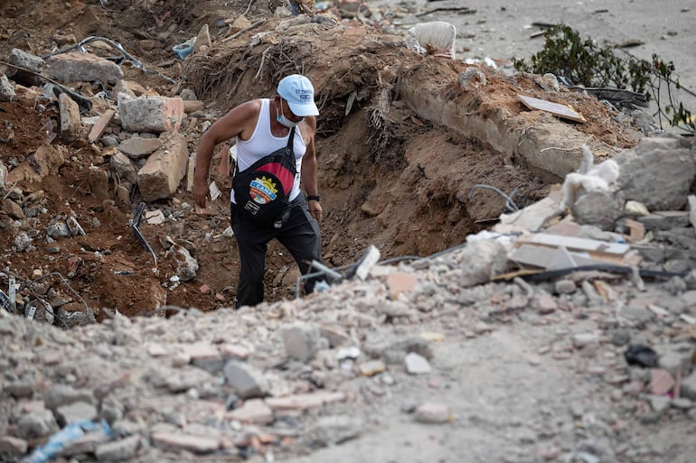 Un voluntario camina este domingo entre escombros de un edificio derrumbado por el doble terremoto en La Guaira (Venezuela).
