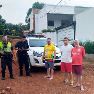 Policías de Ciudad del Este con los suboficiales supuestamente amenazados, Miguel Alejandro Britos Benítez (camiseta amarilla) y Bonifacio Fabián Britos Benítez (remera blanca), frente a la casa de estos, que ahora tiene resguardo.