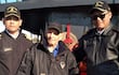 Sixto Sosa Ramírez con chaqueta negra y bastón, acompañado de dos hombres uniformados en la costanera de Encarnación.