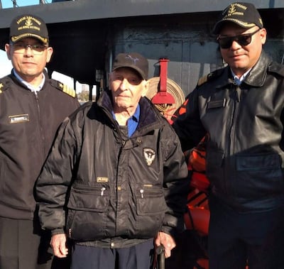 Sixto Sosa Ramírez con chaqueta negra y bastón, acompañado de dos hombres uniformados en la costanera de Encarnación.